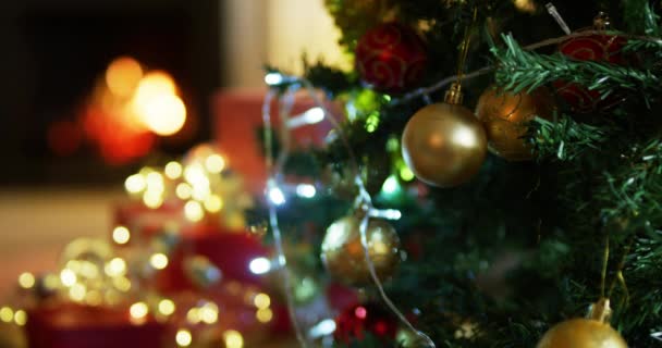 Sluiten Van Stralende Feeënlampjes Kerstballen Een Kerstboom Een Familiekamer Met — Stockvideo