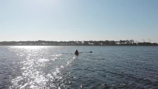 トレーニング中に川の2つのレースシェルで漕ぐ2人の若い大人の白人女性のチームの次のショットでズーム — ストック動画