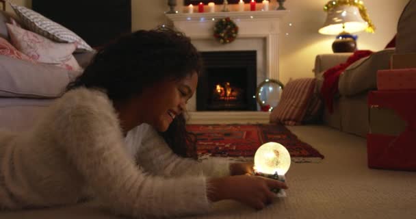 크리스마스 바닥에 소녀가 웃으며 눈으로 지구를 바라보고 — 비디오