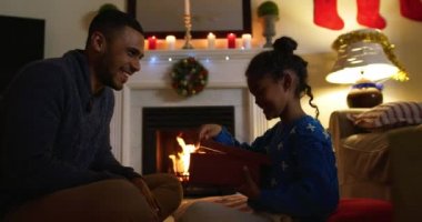 Bir yandan melez bir babanın genç kızıyla birlikte Noel 'de oturma odasında otururken, kız hediyesini açarken babası onu izliyor.