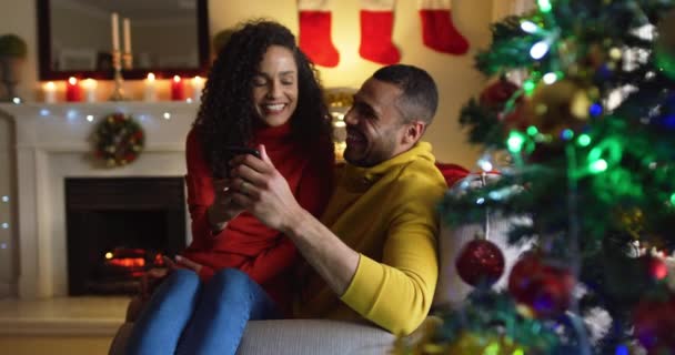 성탄절 소파에 스마트폰으로 남자의 무릎에 여성의 — 비디오
