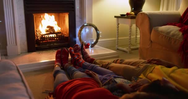 圣诞节的时候 一个混血儿和他们年幼的女儿躺在客厅里 躺在壁炉边的地板上取暖 — 图库视频影像