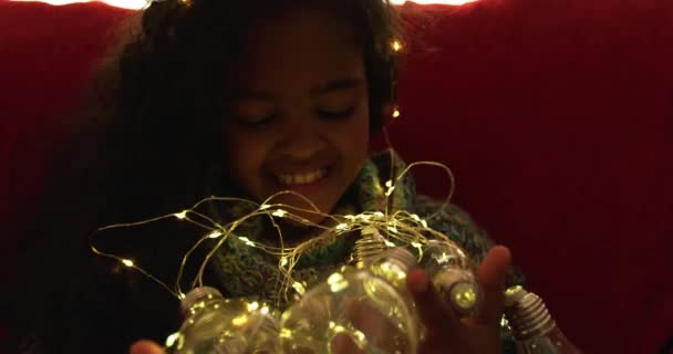 Noel Oturma Odasında Oturan Melez Bir Kızın Görüntüsü Kanepede Oturuyor — Stok video
