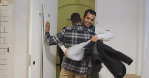 一个年轻的混血种族男子在前门迎接一群年轻的 多族裔的男女朋友 然后来到一个公寓参加一个聚会的后视镜 — 图库视频影像