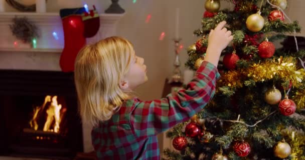 Vista Lateral Jovem Caucasiano Decorando Árvore Natal Sua Sala Estar — Vídeo de Stock