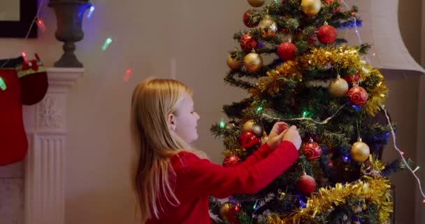 Sidovy Över Ung Vit Flicka Som Dekorerar Julgranen Sitt Vardagsrum — Stockvideo