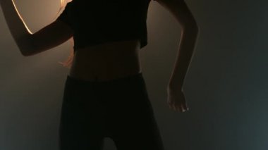 Siyah bir arka planda siluet içinde dans eden beyaz bir kadının ön tarafı. Siyah arka planda vücut dili ile ifade eden duygusal ve duygusal dansçı.