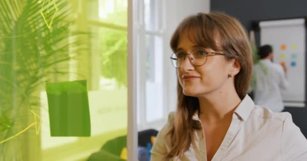 사무실에서 일하는 끈적끈적 노트가 칠판에 뒤에서 일하는 — 비디오