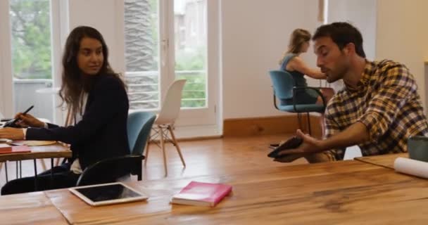 남녀가 창조적 사업의 사무실에서 일하고 책상에 이야기하고 여성에게 태블릿 컴퓨터를 — 비디오