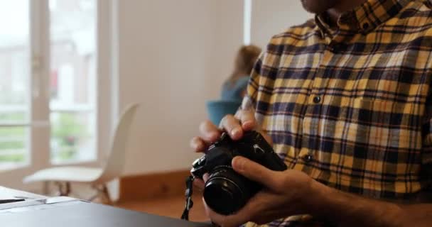 一个千年白人男子在一家创意企业的办公室里工作 坐在办公桌前 用相机拍摄的照片 — 图库视频影像