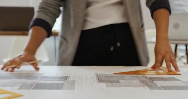 在一家创意企业的办公室里工作 站在办公桌前 绘制建筑图纸的一个千年白人妇女的正中镜头 — 图库视频影像