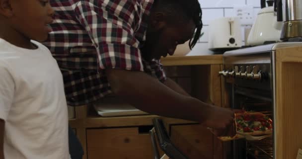 Vista Lateral Perto Pai Afro Americano Milenar Colocando Uma Pizza — Vídeo de Stock