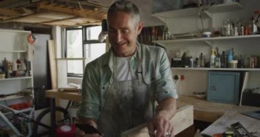 Kafkasyalı bir adamın evinde akıllı telefon kullanarak Diy 'i taklit edişinin ön görüntüsü.
