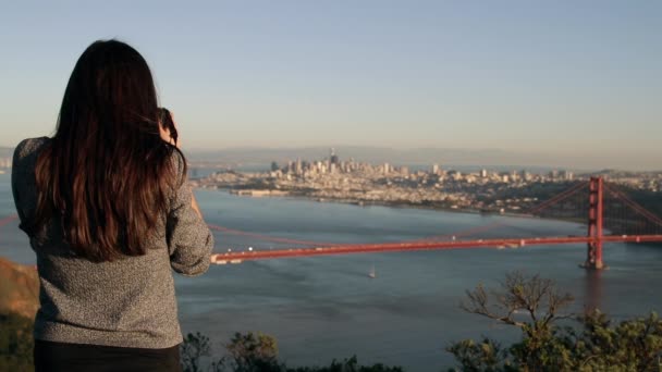 从金门国家娱乐区拍摄金门大桥和旧金山湾地区遥远建筑物的年轻白种女人的后视镜 动作缓慢 — 图库视频影像