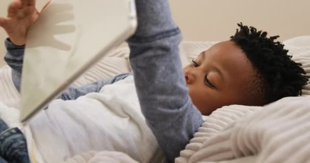 Боковой Вид Маленького Афроамериканского Мальчика Лежащего Дома Сумке Планшетным Компьютером — стоковое видео