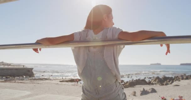 Vista Trasera Una Joven Mujer Caucásica Sentada Soleada Playa Apoyada — Vídeo de stock