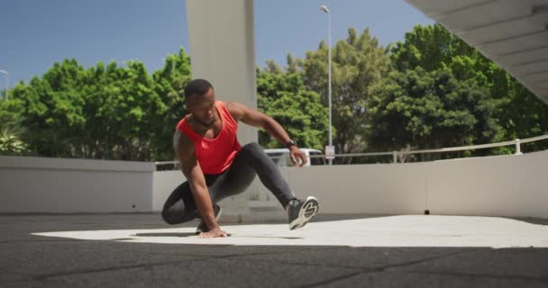 Vooraanzicht Van Een Atletische Afro Amerikaanse Man Sportkleding Hurkend Zijn — Stockvideo