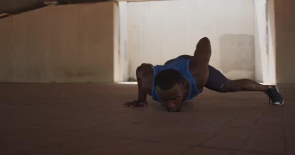 선수가 아프리카 미국인이 앞에서 도시에서 훈련을 받으면서 밑에서 무장강 운동을 — 비디오