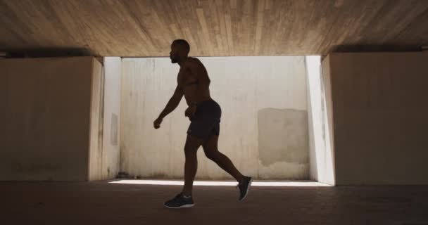 Бічний Вид Несоромливого Афроамериканця Який Робить Вправи Тіні Під Мостом — стокове відео