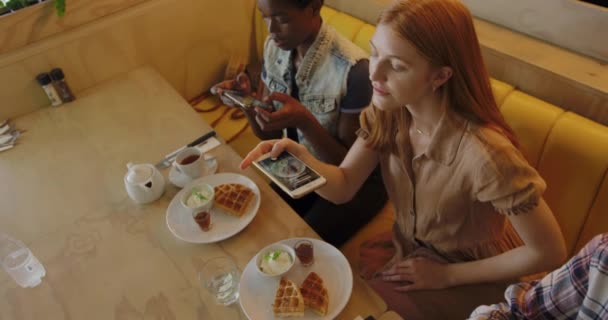 히잡을 머리를 커피숍에서 테이블에 스마트폰을 사용하여 음식을 아프리카 미국인 여성의 — 비디오