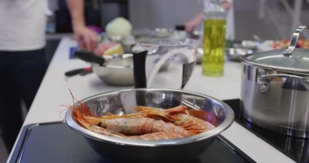 把新鲜的虾仁放在碗里 放在柜台顶上的锅子旁边 厨师们慢吞吞地在后面干活 — 图库视频影像