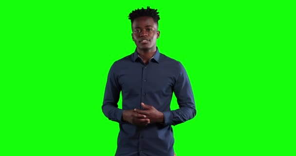緑の画面の背景にカメラを見て 話とジェスチャー 暗いシャツを着て 短い暗い髪を持つ魅力的なアフリカ系アメリカ人ビジネスマン — ストック動画