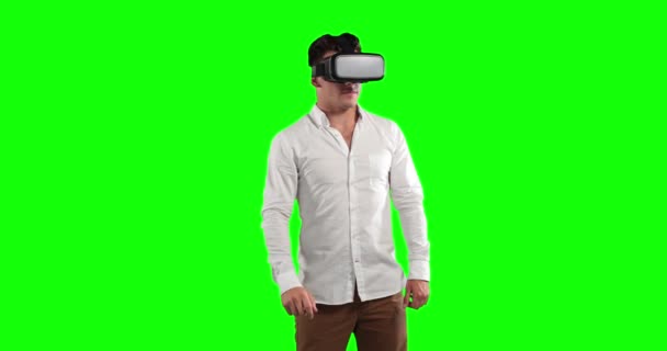 魅力的な白人男性と短い暗い髪 白いシャツを着て Vrゴーグルを使用して 緑の画面の背景に仮想対話型スクリーンを見て — ストック動画