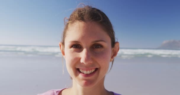 一个白人美女的画像 她喜欢在阳光灿烂的日子在海滩上锻炼 练习瑜伽 看镜头 — 图库视频影像
