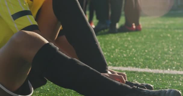 Jogador Futebol Misto Corrida Sentado Campo Jogo Sol Colocando Suas — Vídeo de Stock