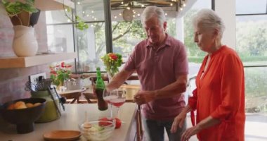 Üst düzey Kafkasyalı çift evde birlikte vakit geçiriyor, Coronavirus covid 19 salgını sırasında karantinada kendilerini izole ediyorlar, ellerinde kırmızı şarap kadehleri, ağır çekim.