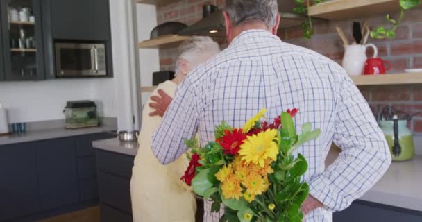 上了年纪的高加索夫妇一起呆在家里 在禽流感流行期间自我隔离 男人送花给女人 动作缓慢 — 图库视频影像