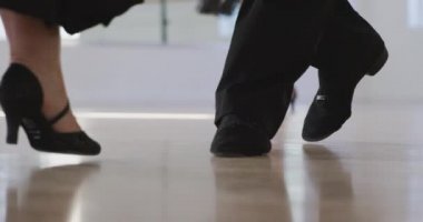 Düşük ırk erkek dans hocasının dans stüdyosunda dans dersi alması, yavaş çekimde bir grup Kafkas yaşlıya dans adımları göstermesi.