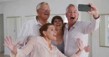 Bir grup mutlu erkek ve bayan arkadaş balo salonunda birlikte vakit geçiriyorlar, dans kursuna katılıyorlar, yavaş çekimde selfie çekiyorlar.