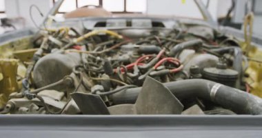 Açık bir araba motorunun çekimini yapmak, bir kasaba atölyesinde dikilmek, onarılmaya hazır olmak.