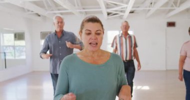 Bir grup mutlu erkek ve bayan arkadaş bir balo salonunda birlikte vakit geçiriyorlar, dans kursuna katılıyorlar, ağır çekimde dans ediyorlar.