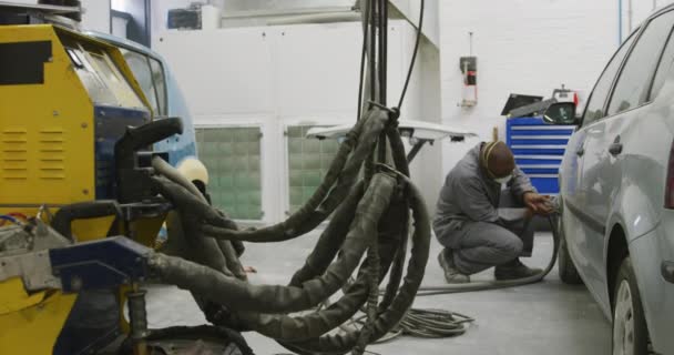 在乡镇车间工作的非裔美国男性汽车修理工 戴着面罩 用慢动作磨床擦亮汽车的侧面 — 图库视频影像