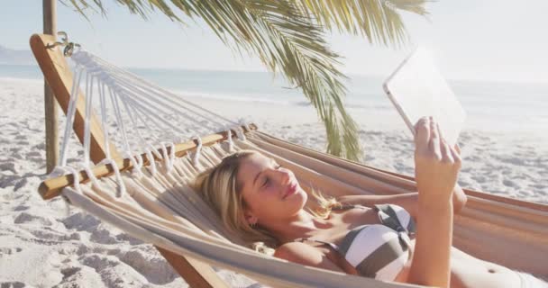 Caucasian Woman Enjoying Time Beach Lying Hammock Using Her Tablet — Stock Video