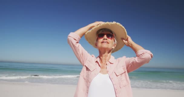 카프카스 할머니는 모자를 날느린 동작으로 웃으면서 해변에서 시간을 즐기고 있었다 — 비디오
