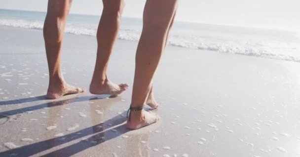 一对白种人夫妇在海滩上享受着一段低矮的时光 在阳光灿烂的一天慢吞吞地走向大海 放宽暑期泳滩假期 — 图库视频影像