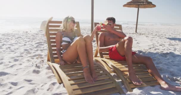 Caucasian Couple Enjoying Time Beach Sitting Sunbeds Drinking Drinks Smiling — Stock Video