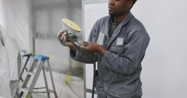 在乡镇车间工作的非裔美国汽车技工 检查并连接慢动作汽车抛光工具 — 图库视频影像