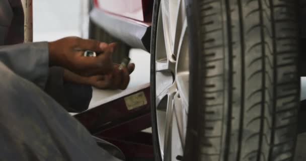 Mecánico Coche Afroamericano Trabajando Taller Municipal Atornillando Una Rueda Coche — Vídeo de stock