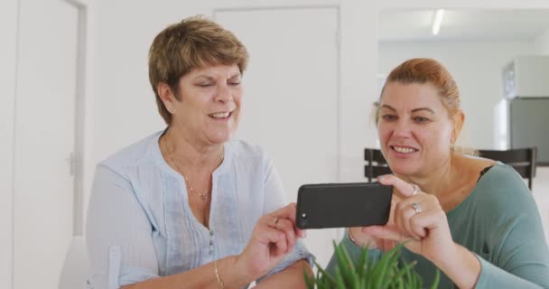 Duas Amigas Idosas Caucasianas Felizes Sentadas Uma Mesa Juntas Socializando — Vídeo de Stock