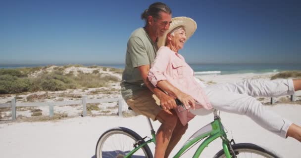 Pareja Mayores Caucásicos Disfrutando Del Tiempo Playa Montando Una Bicicleta — Vídeo de stock