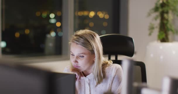 夜遅くに現代のオフィスで働いている疲れ白人の実業家 遅い動きでコンピュータ画面を見てコンピュータを使用して机に座って — ストック動画