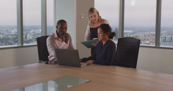現代のオフィスで一緒に働いている混合レースのビジネスマンと白人とアジアのビジネスマンの女性 ファイルを保持し ラップトップコンピュータを使用して話を スローモーションでプロジェクトを議論 — ストック動画