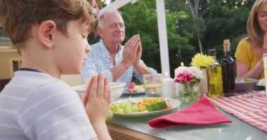 Çok nesildir Kafkas ailesi bahçede birlikte vakit geçirir, yemek masasında otururlar, gözleri kapalı dua ederler, ağır çekimde..