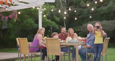 Çok nesildir Kafkas ailesi bahçede birlikte vakit geçiriyorlar, yemek masasında oturuyorlar, akıllı telefon kullanıyorlar, ağır çekimde..