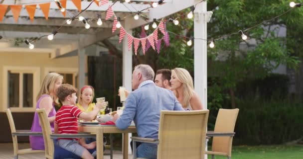多代白人家庭一起在花园度过时光 坐在餐桌前 慢吞吞地敬酒 — 图库视频影像