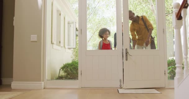 アフリカ系アメリカ人のカップル彼らの息子と娘彼らの家の正面玄関に入ると 子供たちはバックパックを着用し 前方に走り スローモーションで — ストック動画